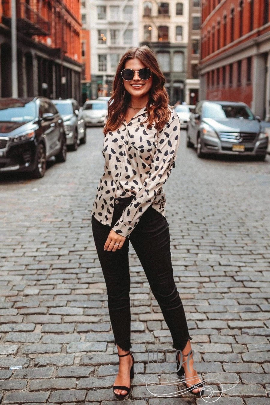 loose long sleeve top made with lightweight material with a button-up front closure, a collared neckline, an accent chest pocket, and a relaxed silhouette that falls into a rounded hemline on a neutral leopard print fabric