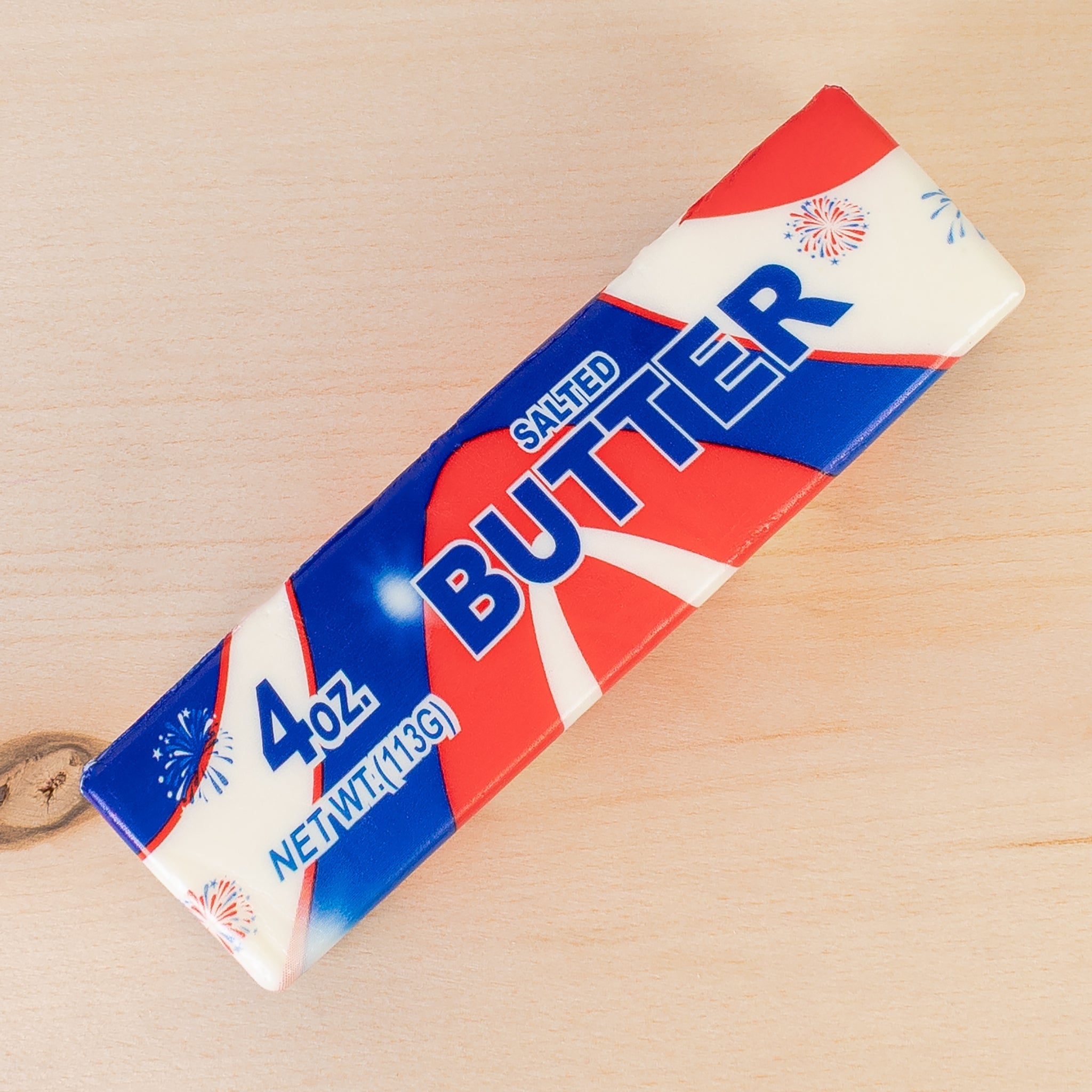 a 4oz USA-inspired butter-stick foam fidget toy made from slow rise polyurethane (PU) foam with a soft texture, a patriotic design (red, white, and blue), playful printed lettering, and individual packaging