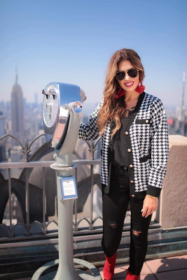 long sleeve jacket with a front gold button closure, contrasting trim on the pockets and edges, pockets (two faux, two functional), and a collared neckline on a black and ivory houndstooth print