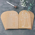 Wooden bookends with engraved design of a bride and groom and text on a dark surface.