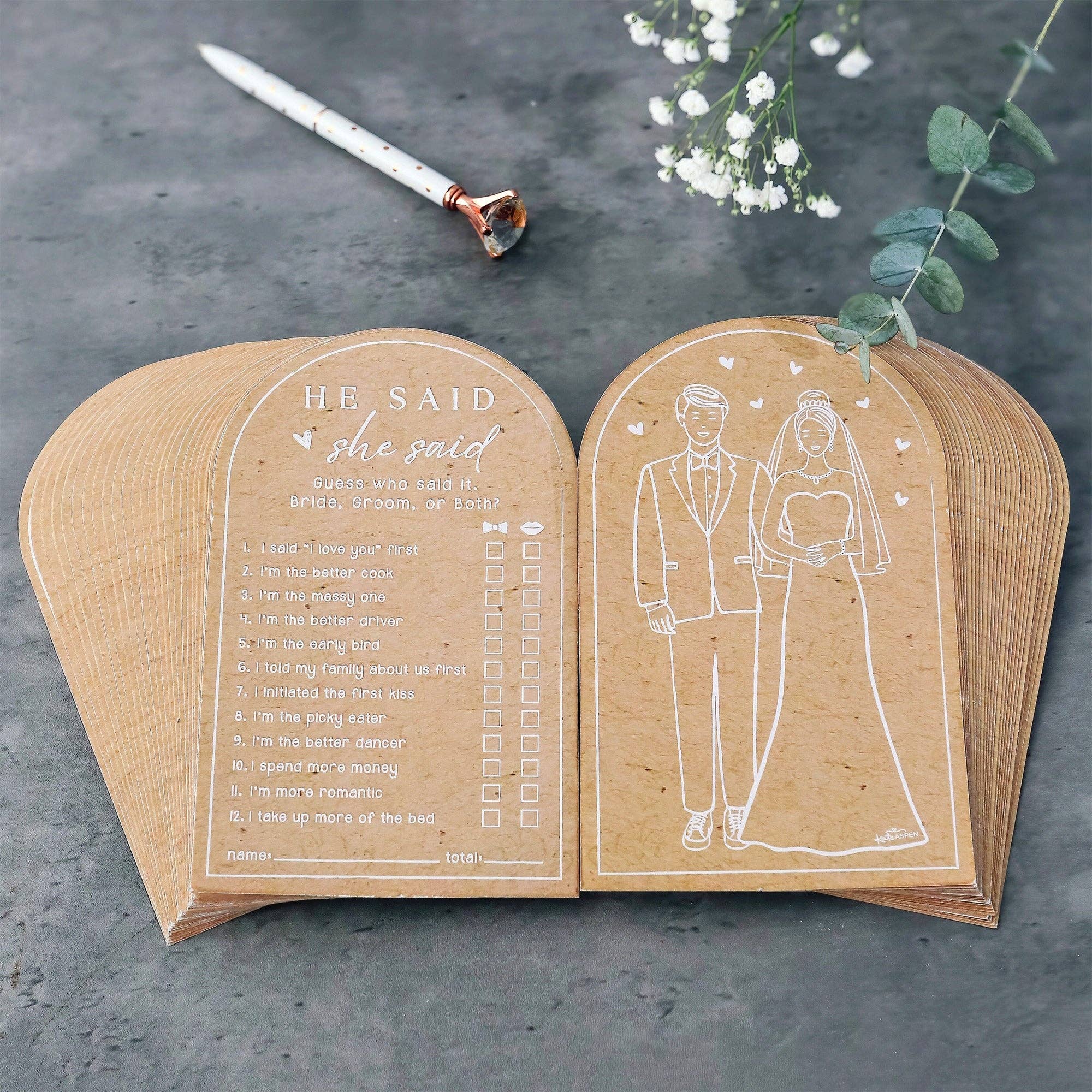 Wooden bookends with engraved design of a bride and groom and text on a dark surface.