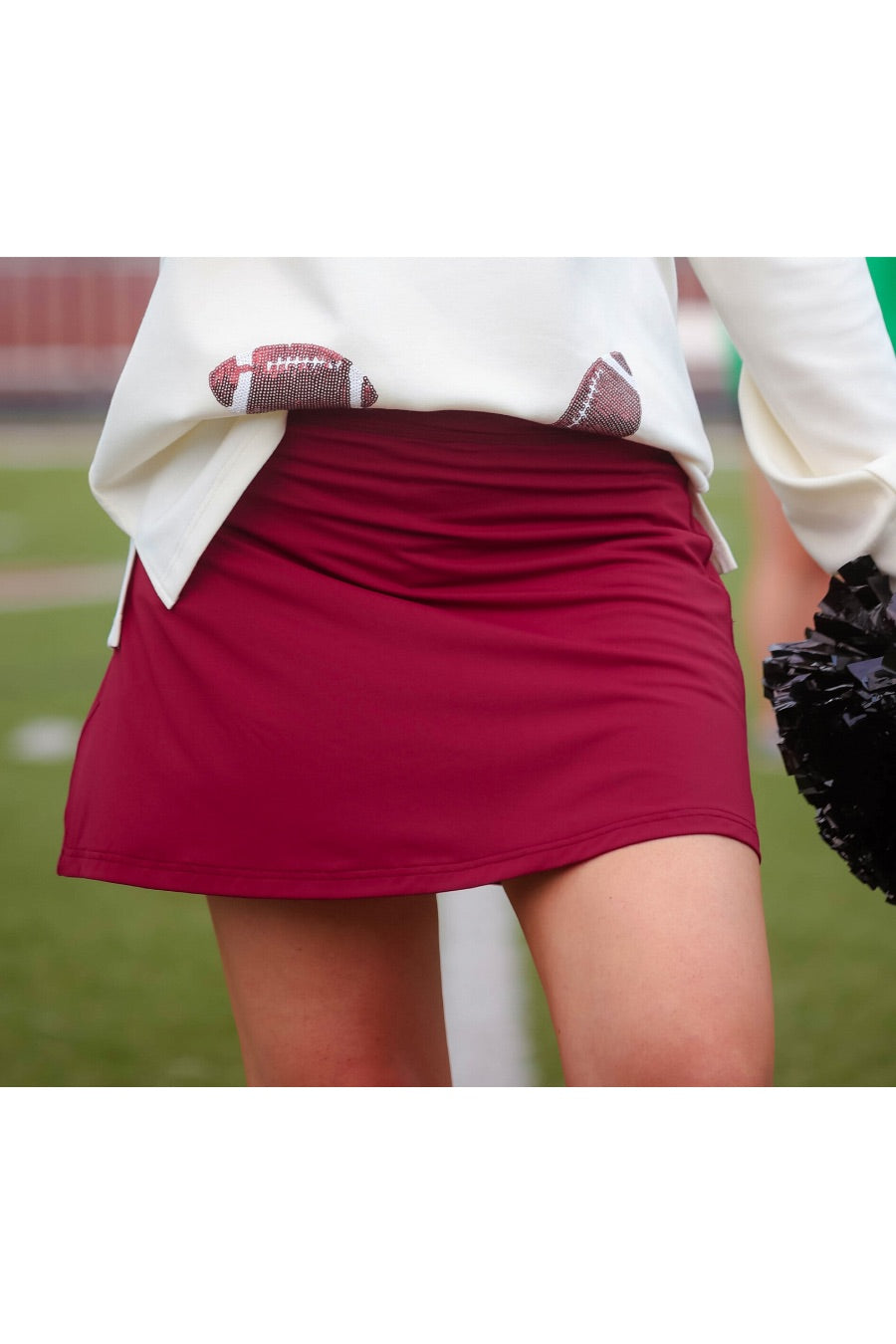 a slimming true to size solid maroon skort with built-in shorts, interior side pockets, and a pleated back