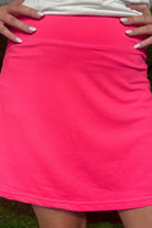 a slimming true to size solid pink skort with built-in shorts, interior side pockets, and a pleated back