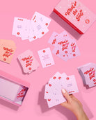 Card game 'What's the Tea?' with cards and packaging on a pink background