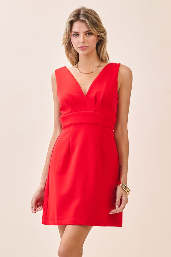 a red sleeveless mini dress with a deep V-neckline, wide waistband, dramatic low back, and self-tie bow detail