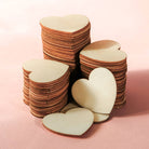 Stack of heart-shaped wooden cutouts on a pink background