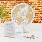 World map decoration with heart-shaped cutouts and a sign on a table.