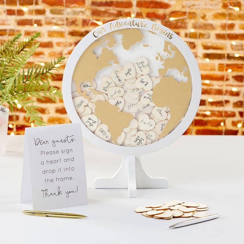 World map decoration with heart-shaped cutouts and a sign on a table.