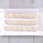 Wooden heart-shaped cutouts on a white paper bag with a wooden surface background