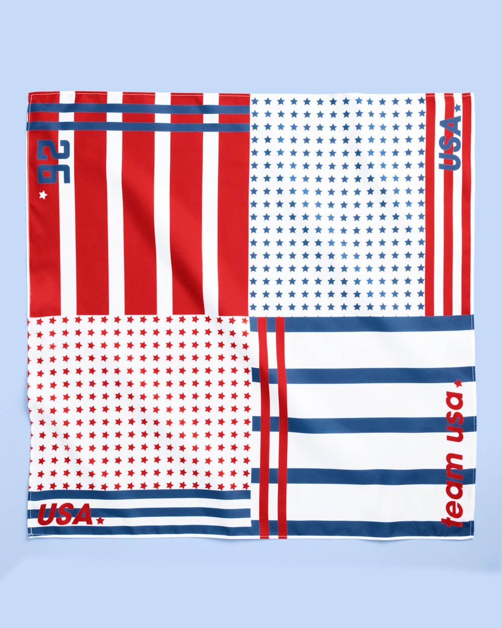 a soft lightweight square polyester bandana with a red, white, and blue flag-inspired print, stars, strips, Team USA lettering, and versatile styling options