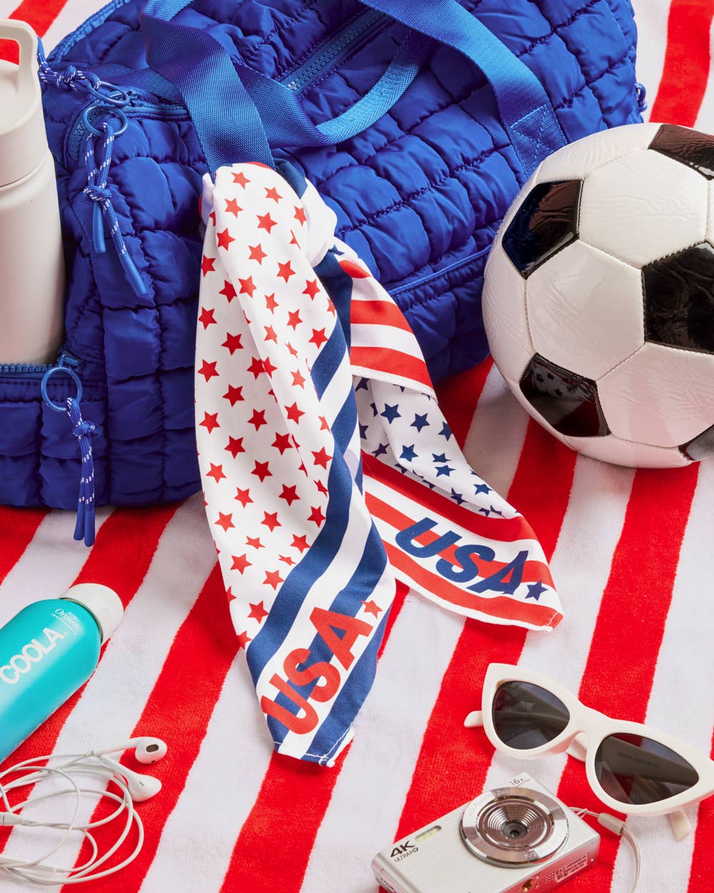 a soft lightweight square polyester bandana with a red, white, and blue flag-inspired print, stars, strips, Team USA lettering, and versatile styling options