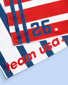 a soft lightweight square polyester bandana with a red, white, and blue flag-inspired print, stars, strips, Team USA lettering, and versatile styling options