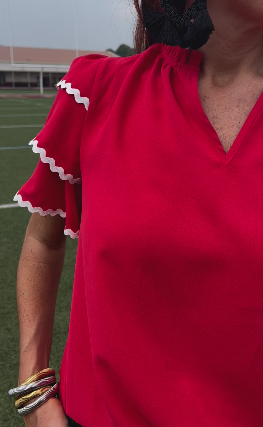 a playful V-neckline top with a ric rac trim detailing on the layered ruffled short sleeves