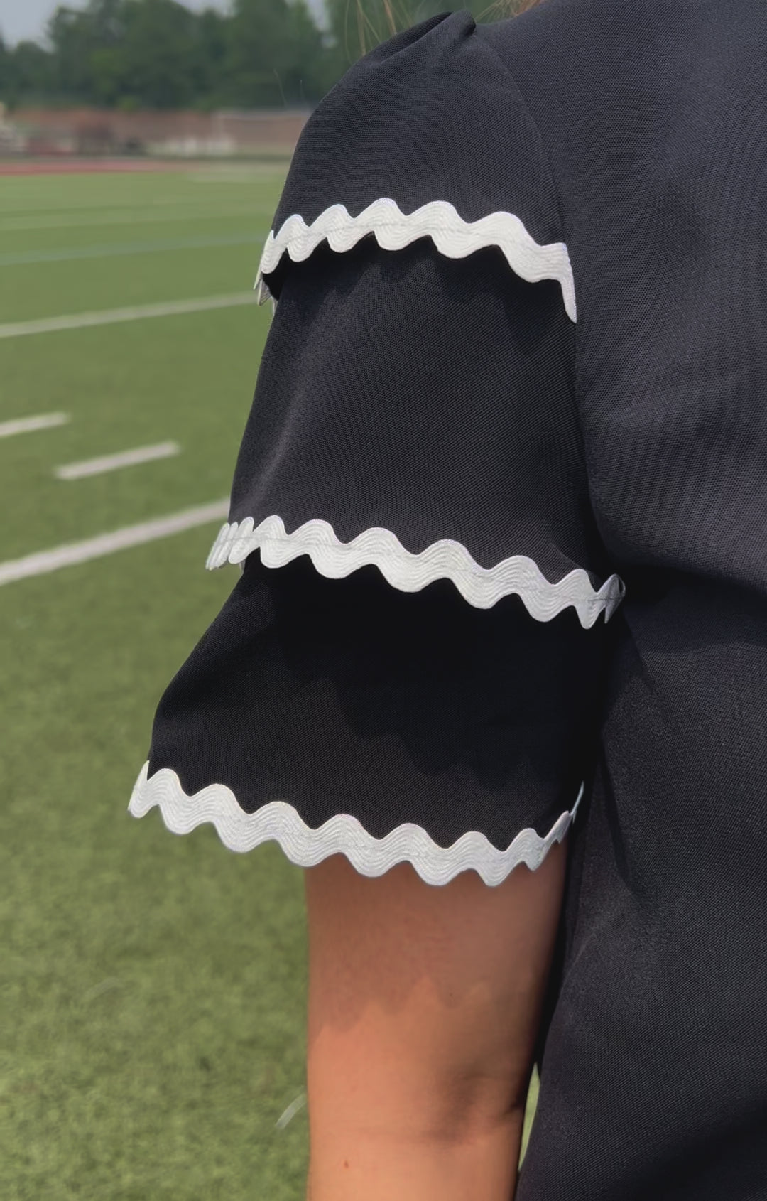 a playful V-neckline top with a ric rac trim detailing on the layered ruffled short sleeves