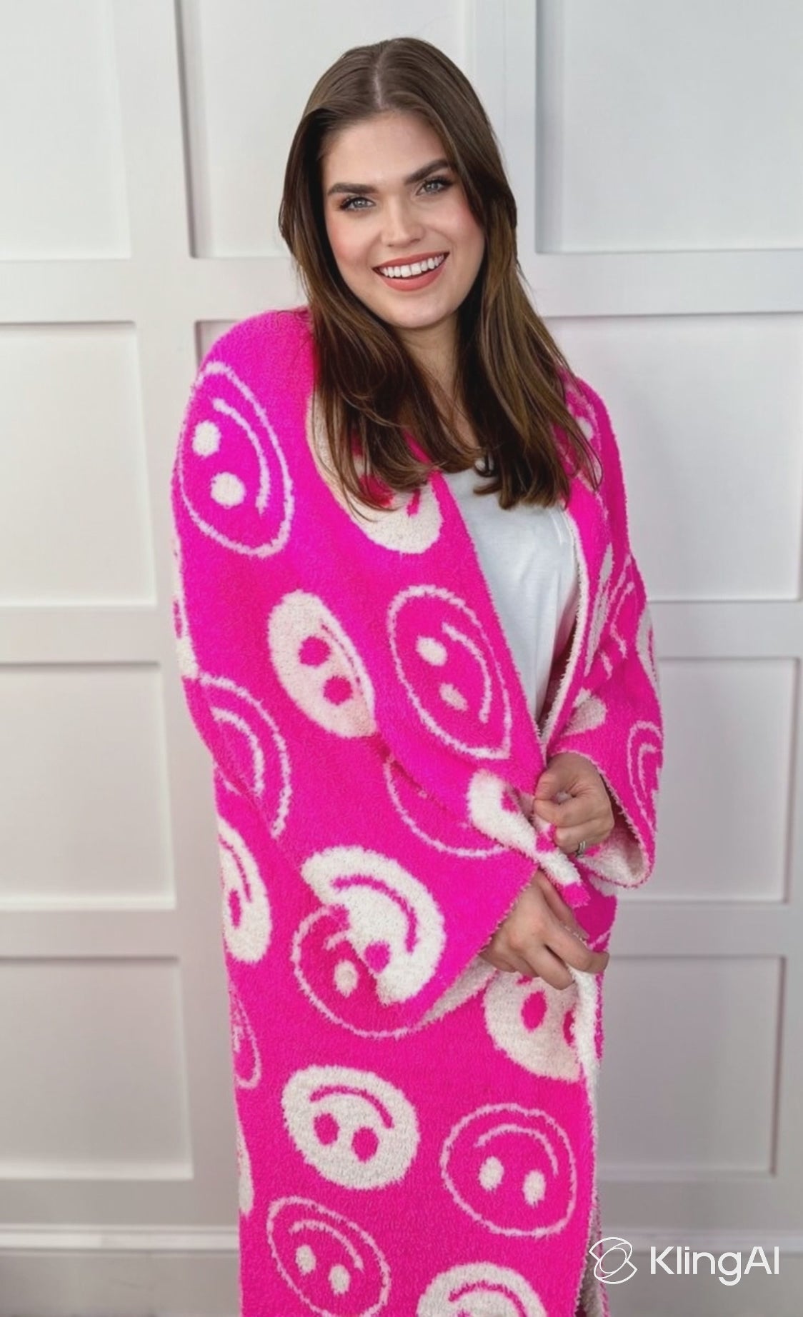 animated video of model snuggling with ultra-soft reversible throw on a pink and white happy face pattern print fabric in pink