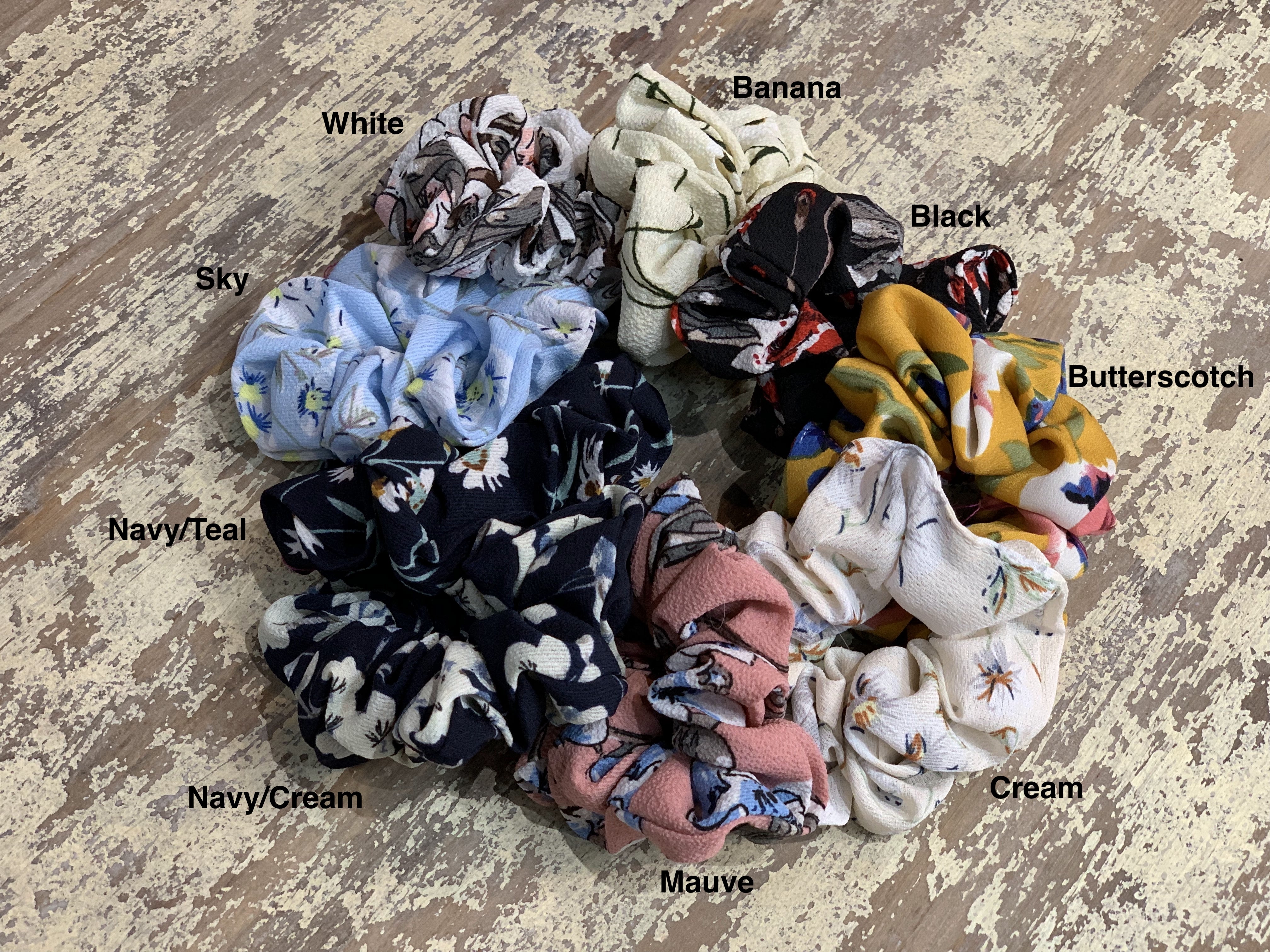 oversized floral scrunchies with lightweight textured fabric, gathered construction, gentle hair-friendly hold, and easy pull-on styling in banana, black, butterscotch, cream, mauve, navy cream, navy teal, sky, and white