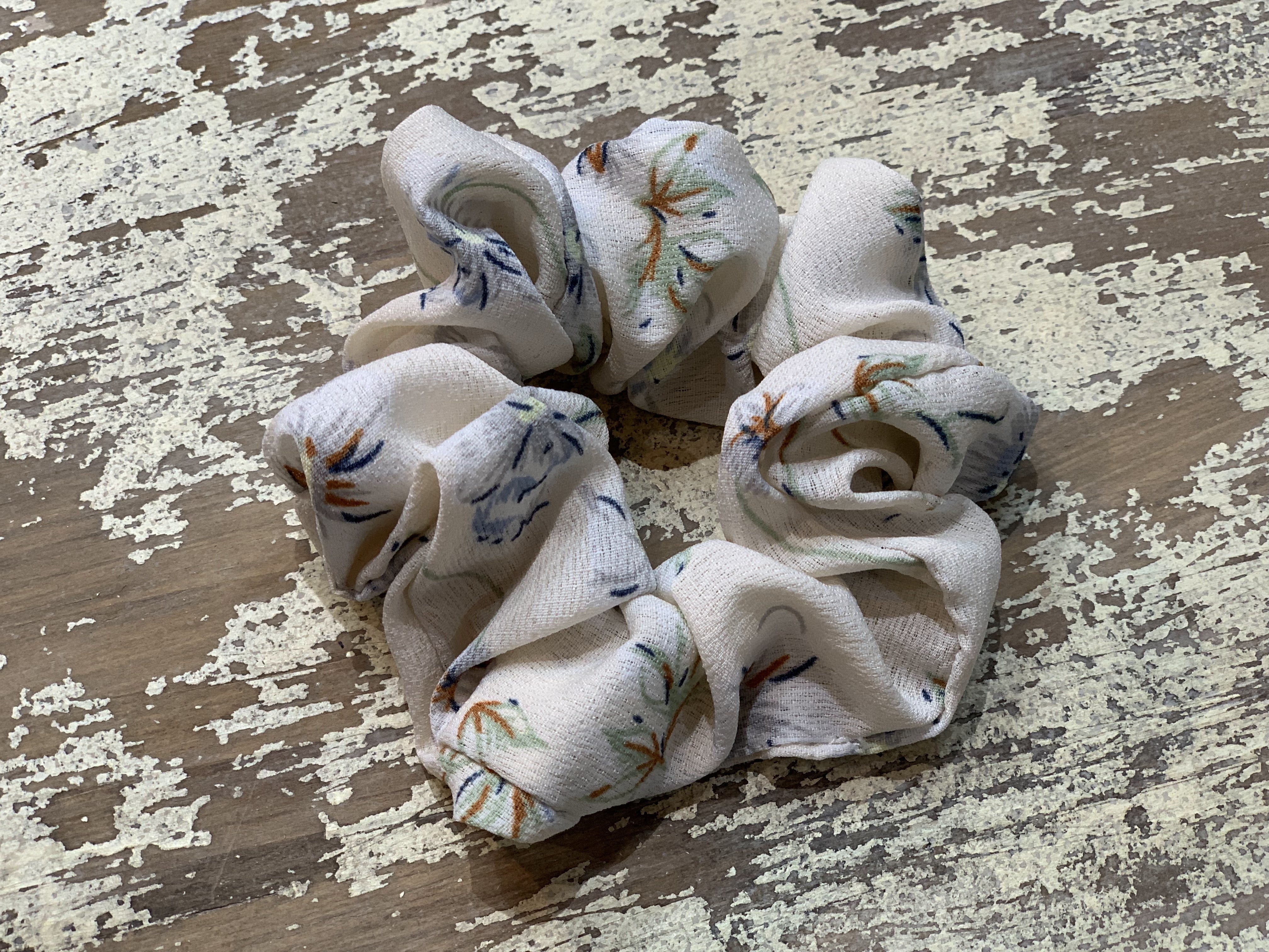 an oversized floral scrunchie with lightweight textured fabric, gathered construction, gentle hair-friendly hold, and easy pull-on styling in cream