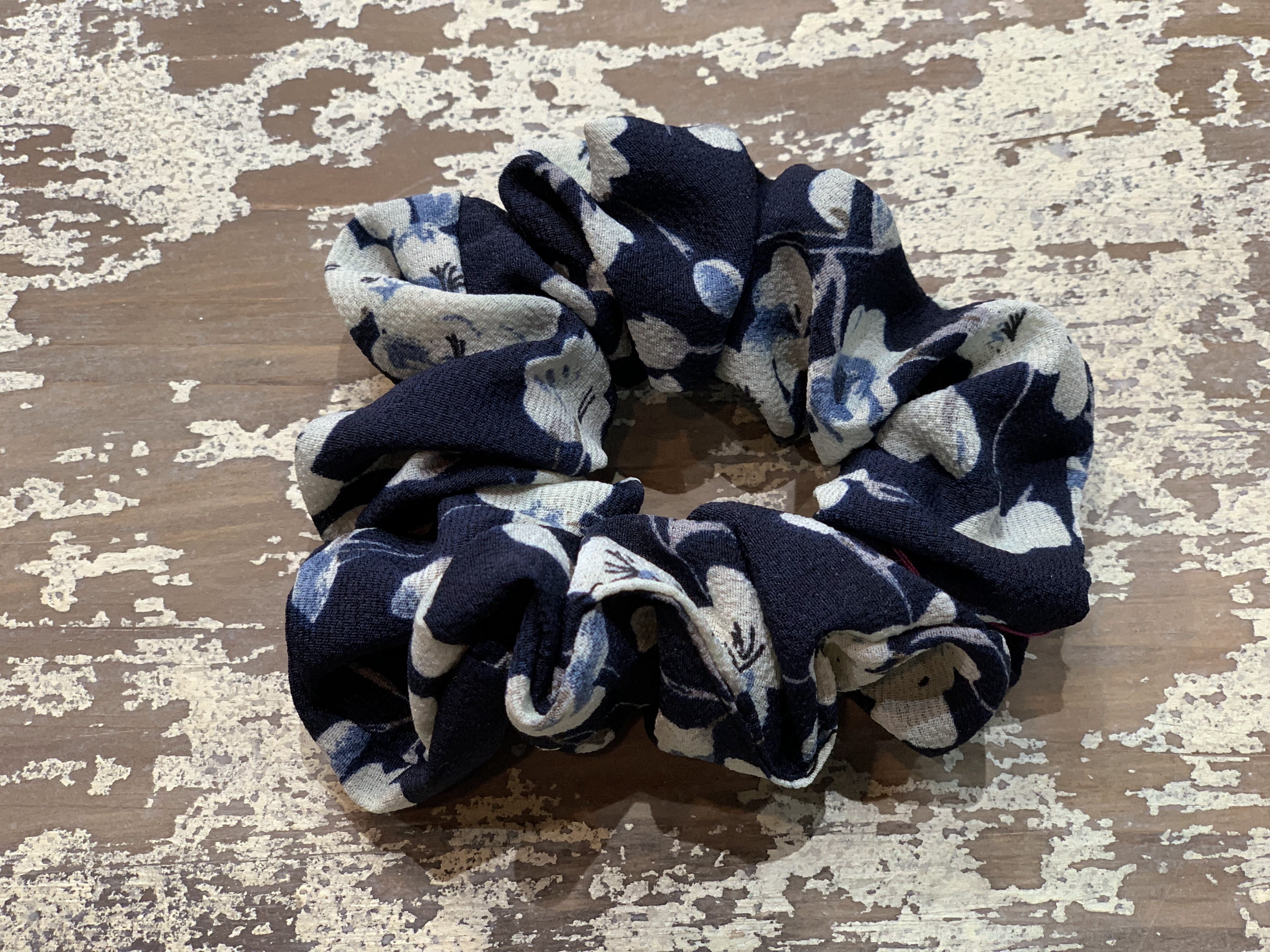 an oversized floral scrunchie with lightweight textured fabric, gathered construction, gentle hair-friendly hold, and easy pull-on styling in navy cream
