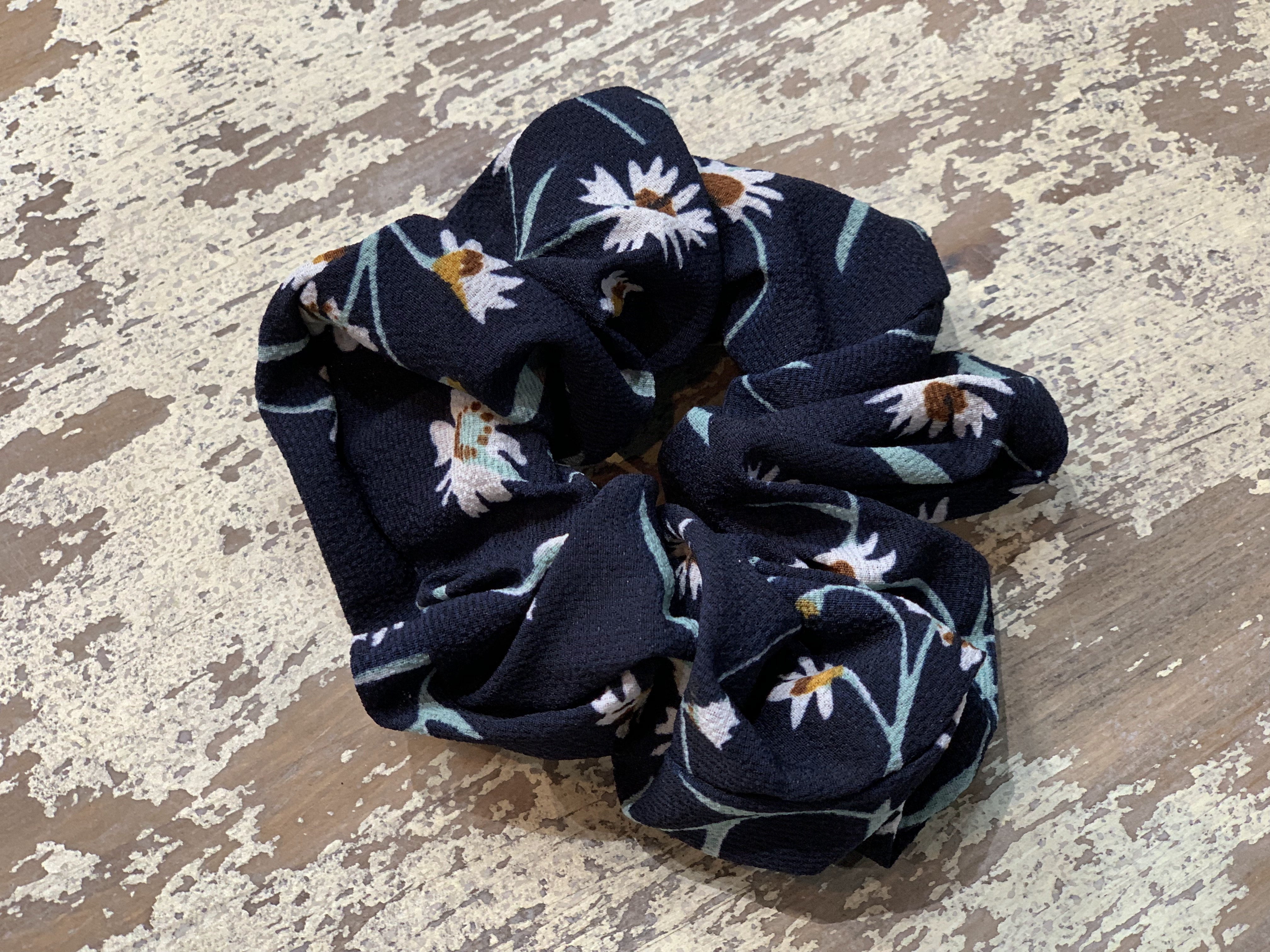 an oversized floral scrunchie with lightweight textured fabric, gathered construction, gentle hair-friendly hold, and easy pull-on styling in navy teal