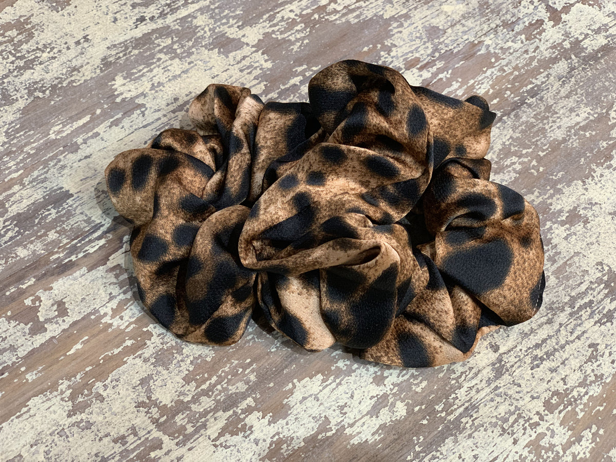 an oversized satin-look leopard scrunchie with glossy animal print fabric, plush gathered construction, lightweight feel, and gentle hair-friendly hold in leopard chocolate