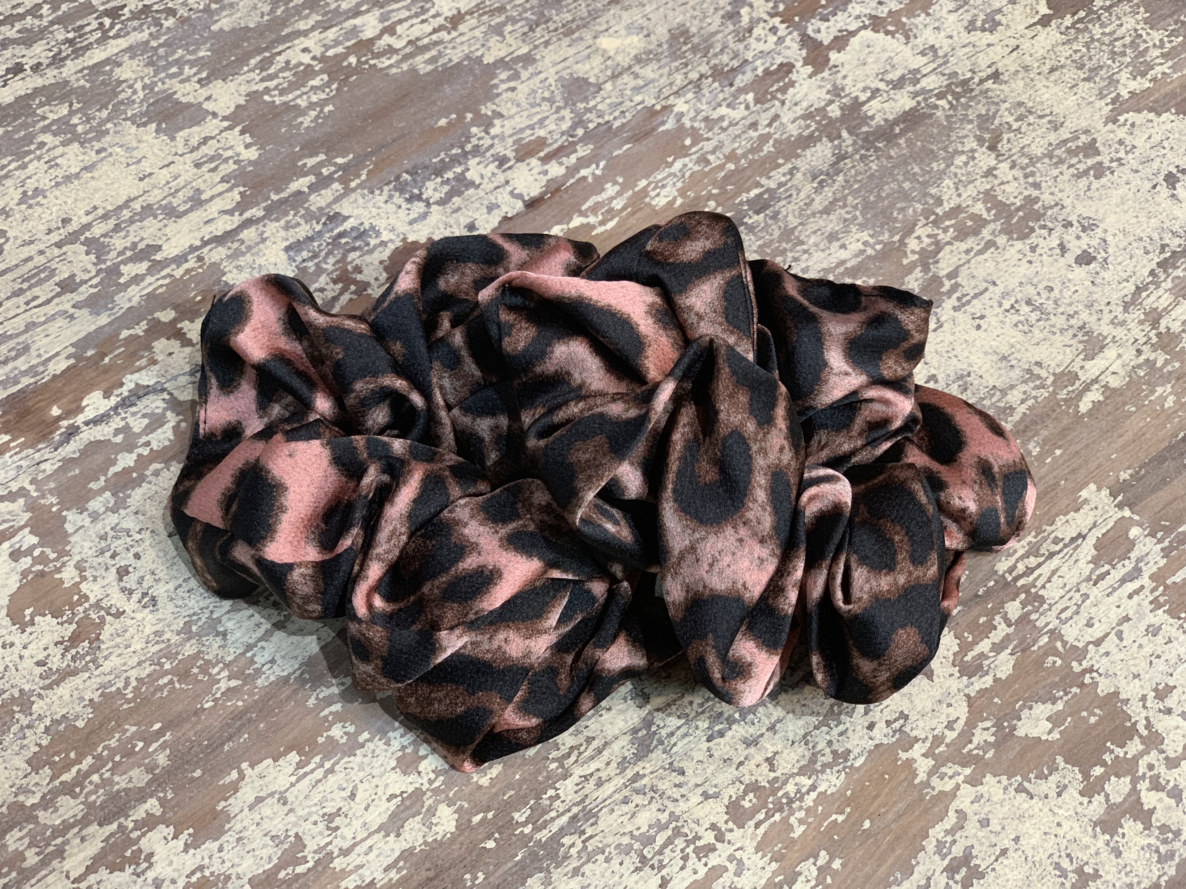 an oversized satin-look leopard scrunchie with glossy animal print fabric, plush gathered construction, lightweight feel, and gentle hair-friendly hold in leopard mauve