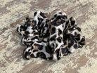 an oversized satin-look leopard scrunchie with glossy animal print fabric, plush gathered construction, lightweight feel, and gentle hair-friendly hold in leopard white