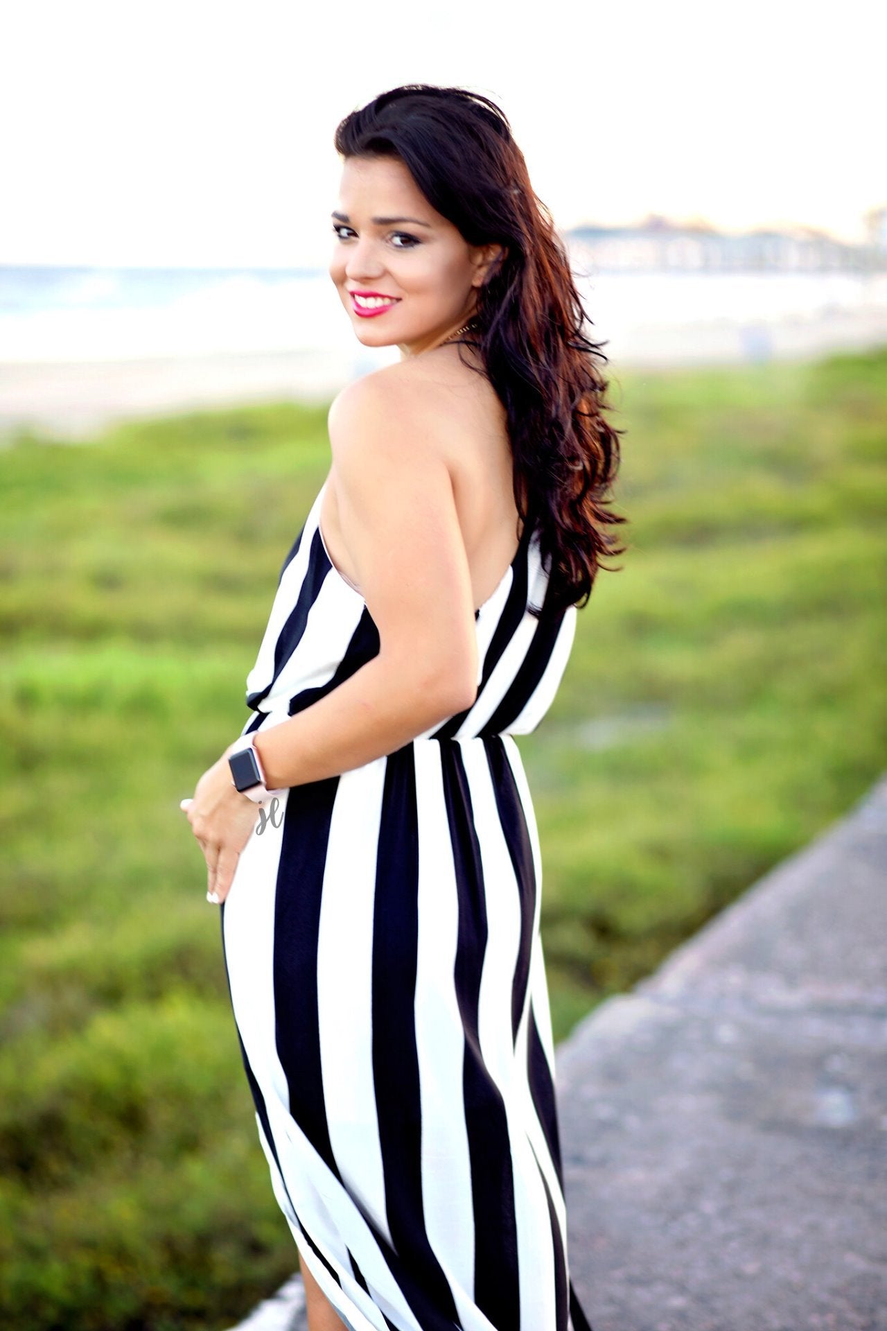 sleeveless maxi dress made of lightweight material with non-adjustable crisscross spaghetti straps, a left side slit, and interior lining, designed on a black and white vertical striped pattern fabric