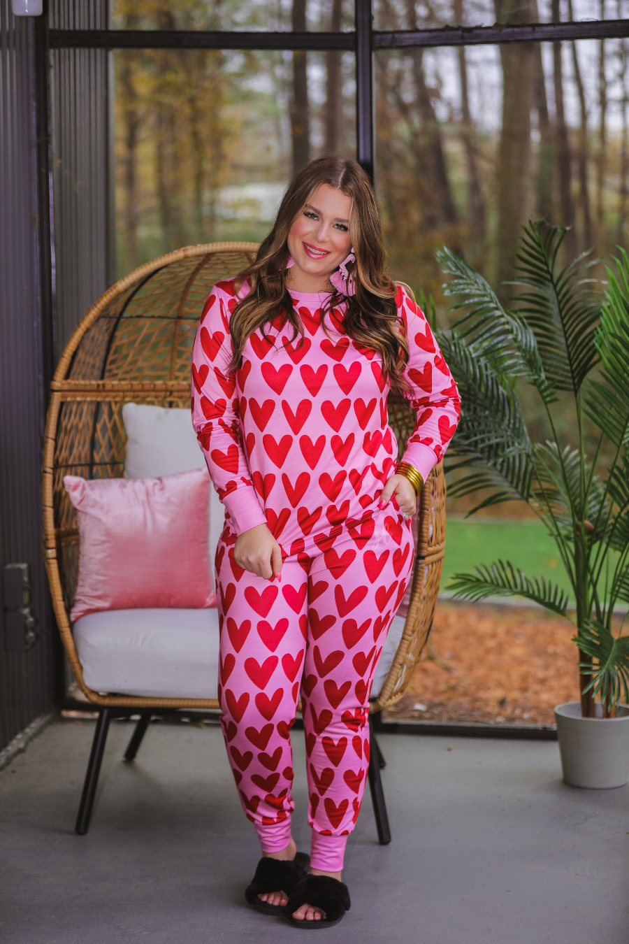 long-sleeve top with red hearts on a solid pink fabric and a rounded neckline paired with matching elastic waistband bottoms