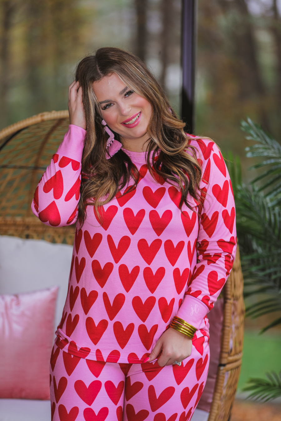 long-sleeve top with red hearts on a solid pink fabric and a rounded neckline paired with matching elastic waistband bottoms