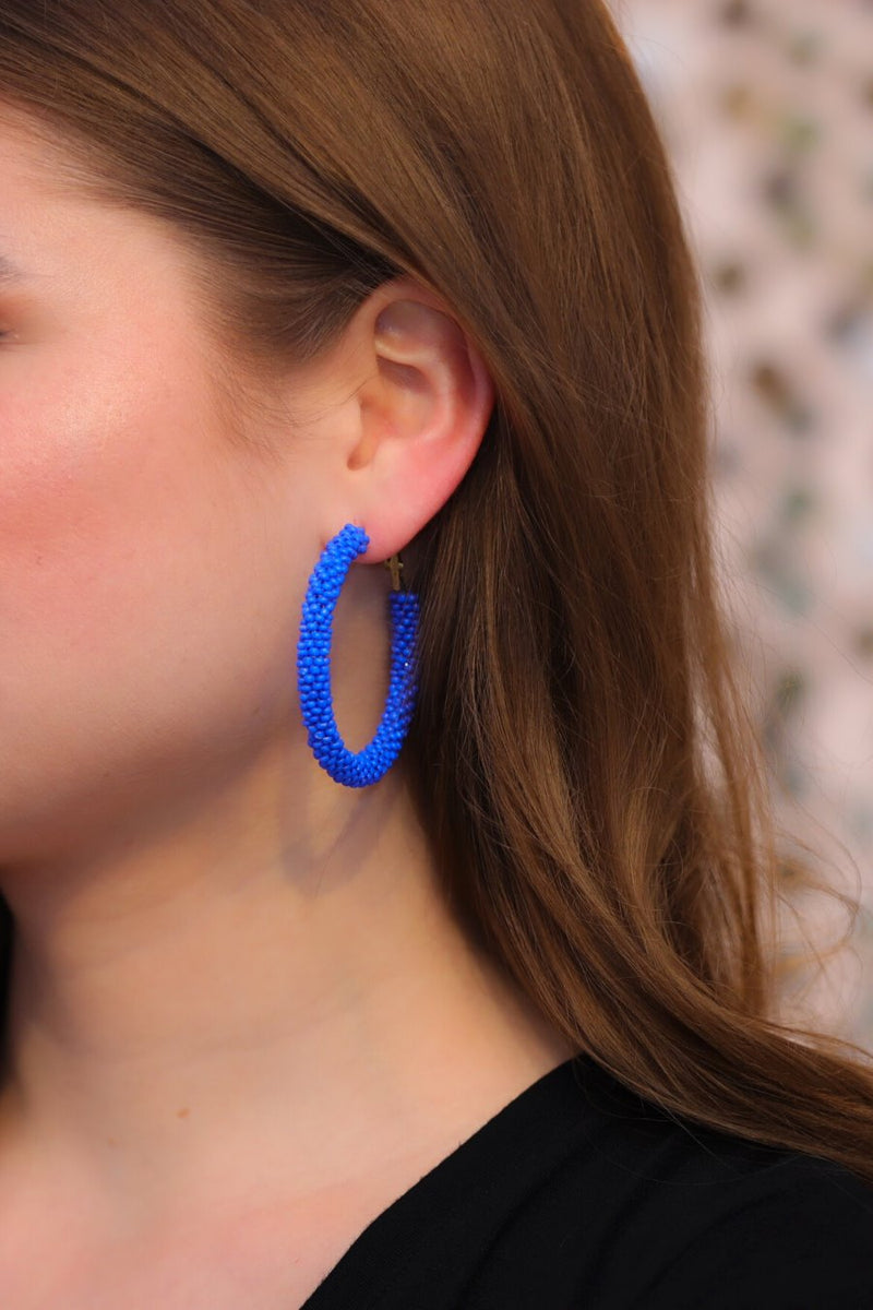 lightweight beaded hoop earrings with a classic circular silhouette in vibrant blue