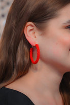 lightweight beaded hoop earrings with a classic circular silhouette in vibrant red
