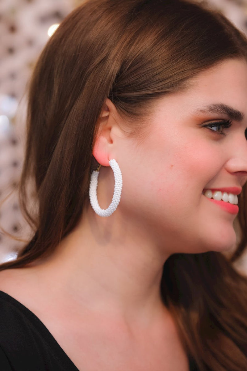 lightweight beaded hoop earrings with a classic circular silhouette in vibrant white