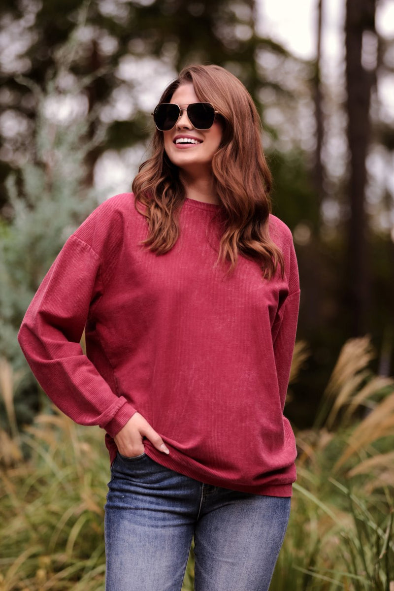 a long-sleeve ribbed textured pullover with a crew neck collar, a vintage wash, and a relaxed fit in red