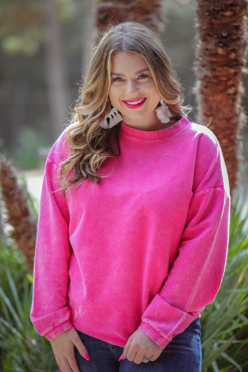 a long-sleeve ribbed textured pullover with a crew neck collar, a vintage wash, and a relaxed fit in pink