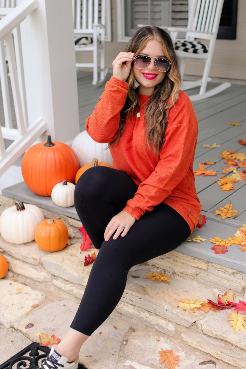 a long-sleeve ribbed textured pullover with a crew neck collar, a vintage wash, and a relaxed fit in rust