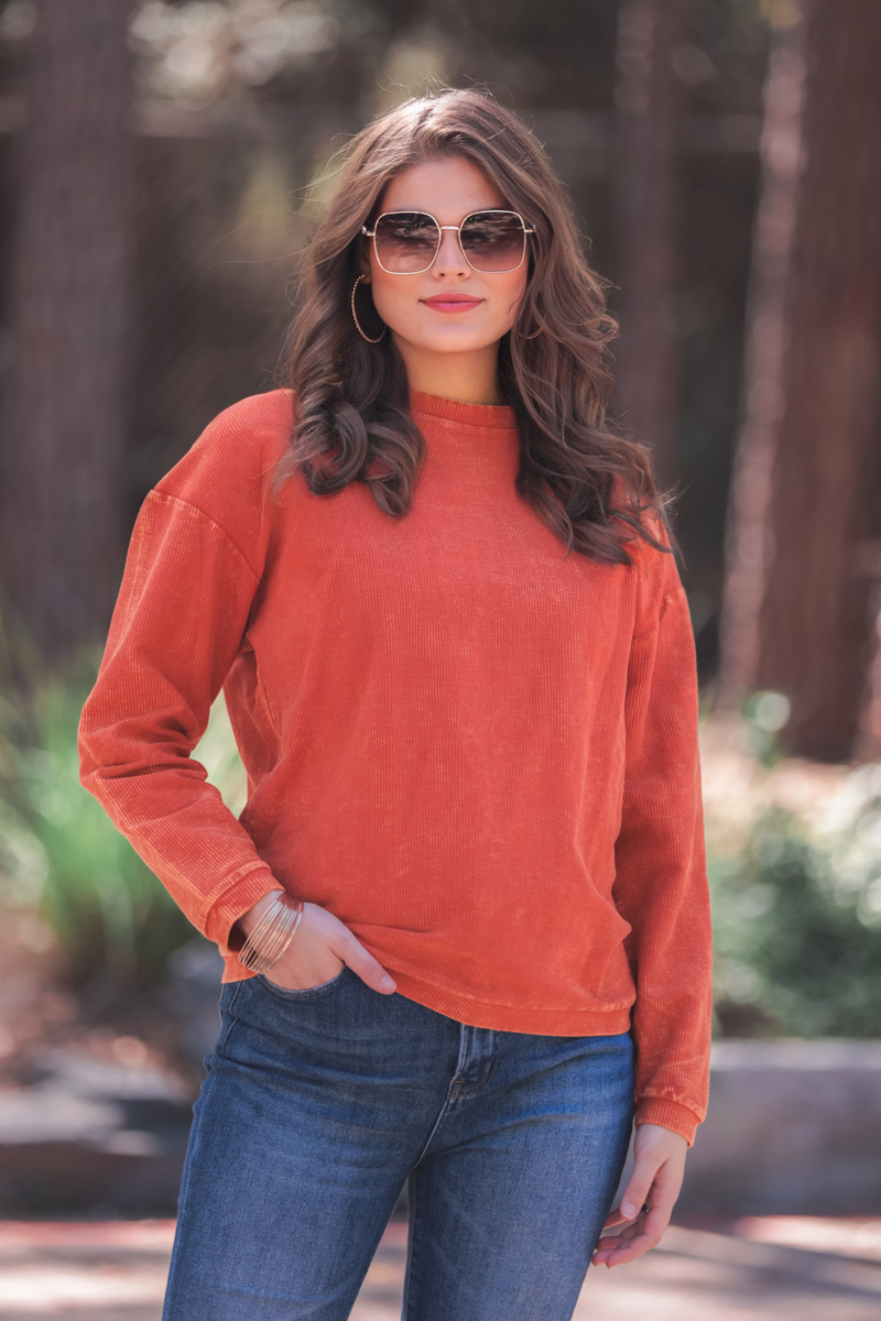 a long-sleeve ribbed textured pullover with a crew neck collar, a vintage wash, and a relaxed fit in rust