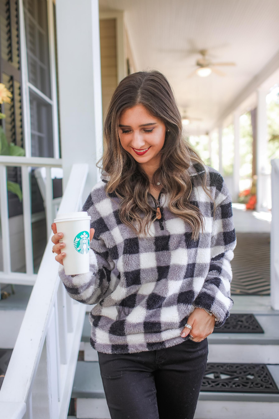 a long-sleeve fluffy pullover with a quarter zip, an adjustable bungee at the hem, and a foldable collar on a classic black and white buffalo plaid pattern fabric