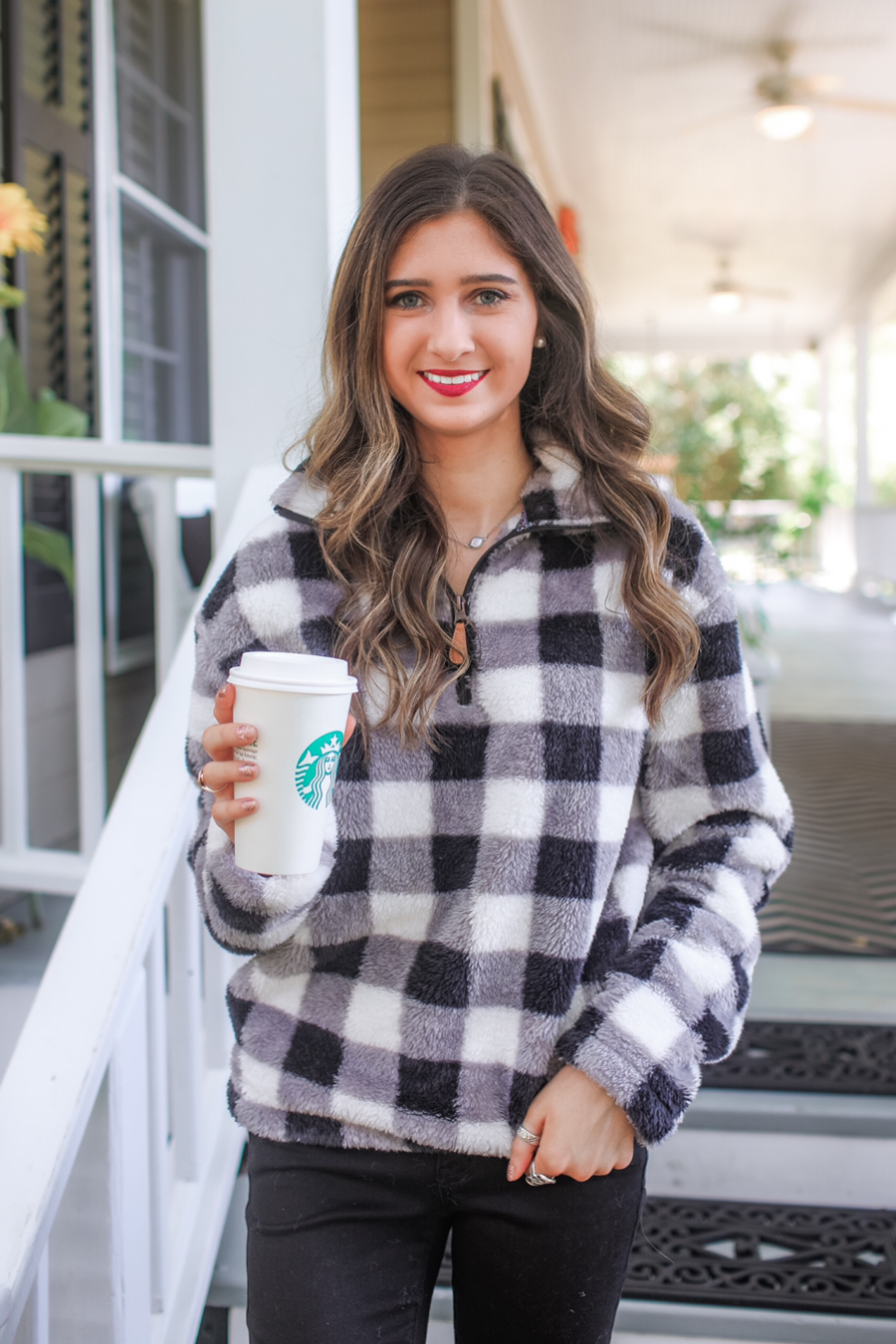 a long-sleeve fluffy pullover with a quarter zip, an adjustable bungee at the hem, and a foldable collar on a classic black and white buffalo plaid pattern fabric