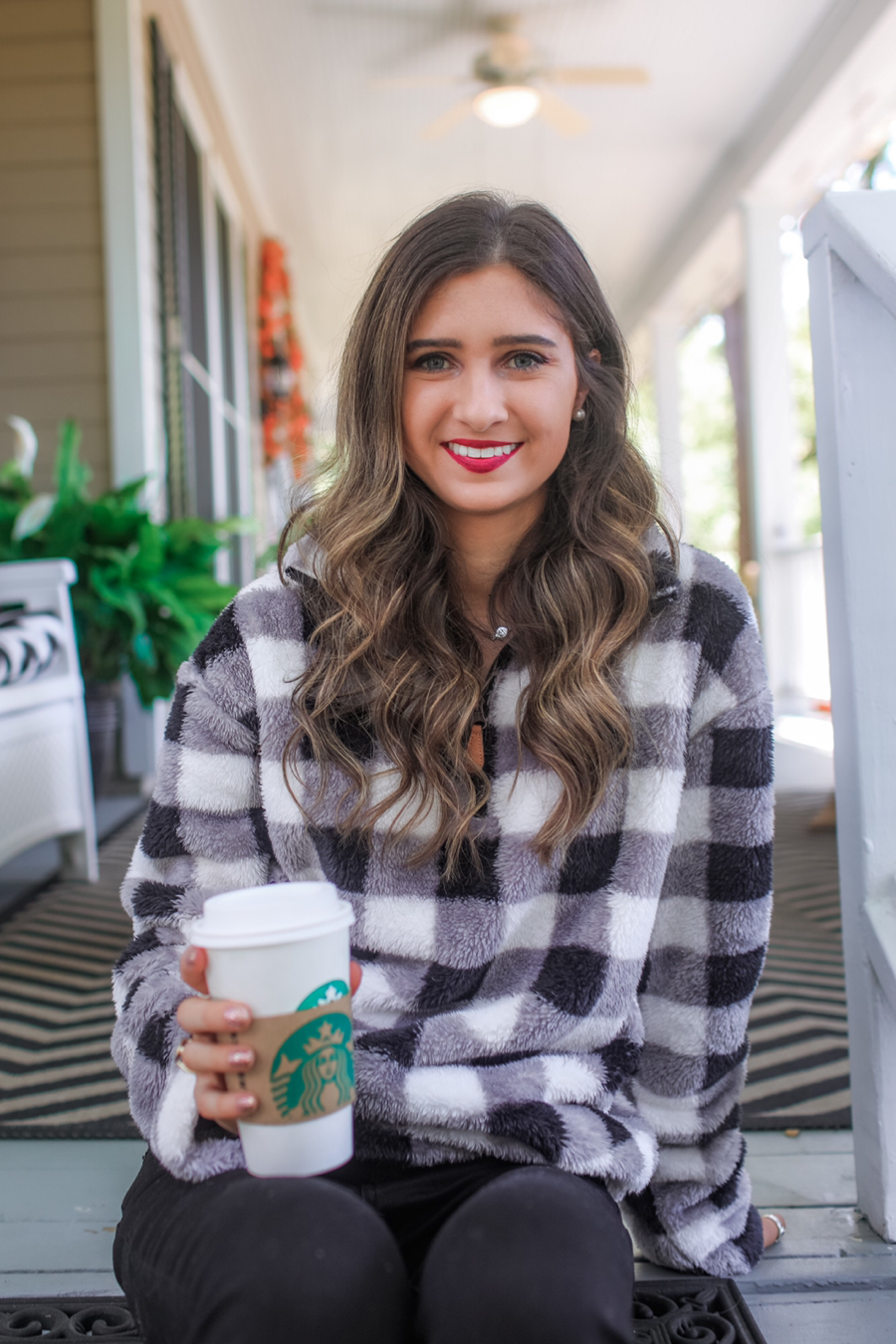 a long-sleeve fluffy pullover with a quarter zip, an adjustable bungee at the hem, and a foldable collar on a classic black and white buffalo plaid pattern fabric