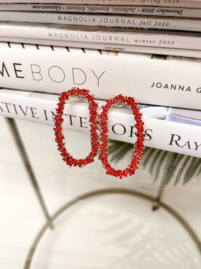 gold cubic zirconia earrings secured with a push backing in a long oval shape in red