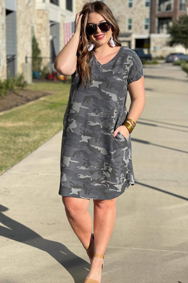 an oversized grey A-line pocket dress with a V-neckline, short sleeves, side pockets, a curved hem, and a terry cloth texture