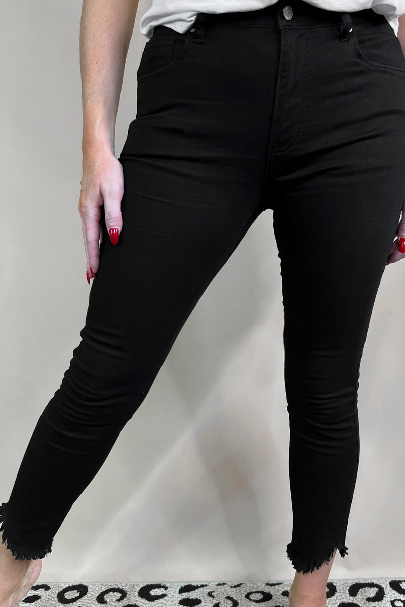 solid black mid-rise jeans with a distressed hem, zip button-up fly, pockets, and some great stretch