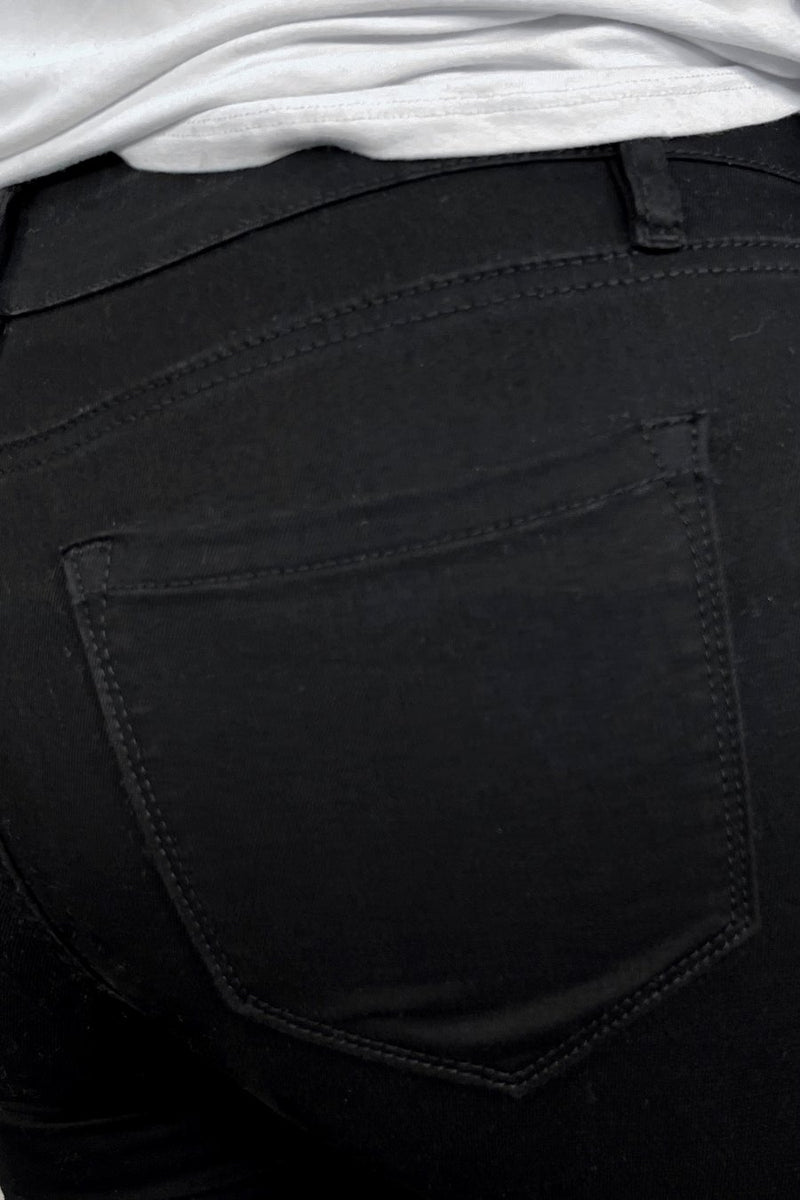 solid black mid-rise jeans with a distressed hem, zip button-up fly, pockets, and some great stretch