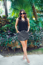 mid-rise relaxed fit everyday skort made of lightweight material with built-in black shorts, drawstring tie, an elastic band on the back, and side pockets, designed on a two-tone black checkered pattern print