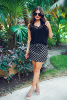mid-rise relaxed fit everyday skort made of lightweight material with built-in black shorts, drawstring tie, an elastic band on the back, and side pockets, designed on a two-tone black checkered pattern print