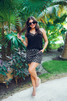 mid-rise relaxed fit everyday skort made of lightweight material with built-in black shorts, drawstring tie, an elastic band on the back, and side pockets, designed on a two-tone black checkered pattern print