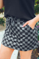 mid-rise relaxed fit everyday skort made of lightweight material with built-in black shorts, drawstring tie, an elastic band on the back, and side pockets, designed on a two-tone black checkered pattern print