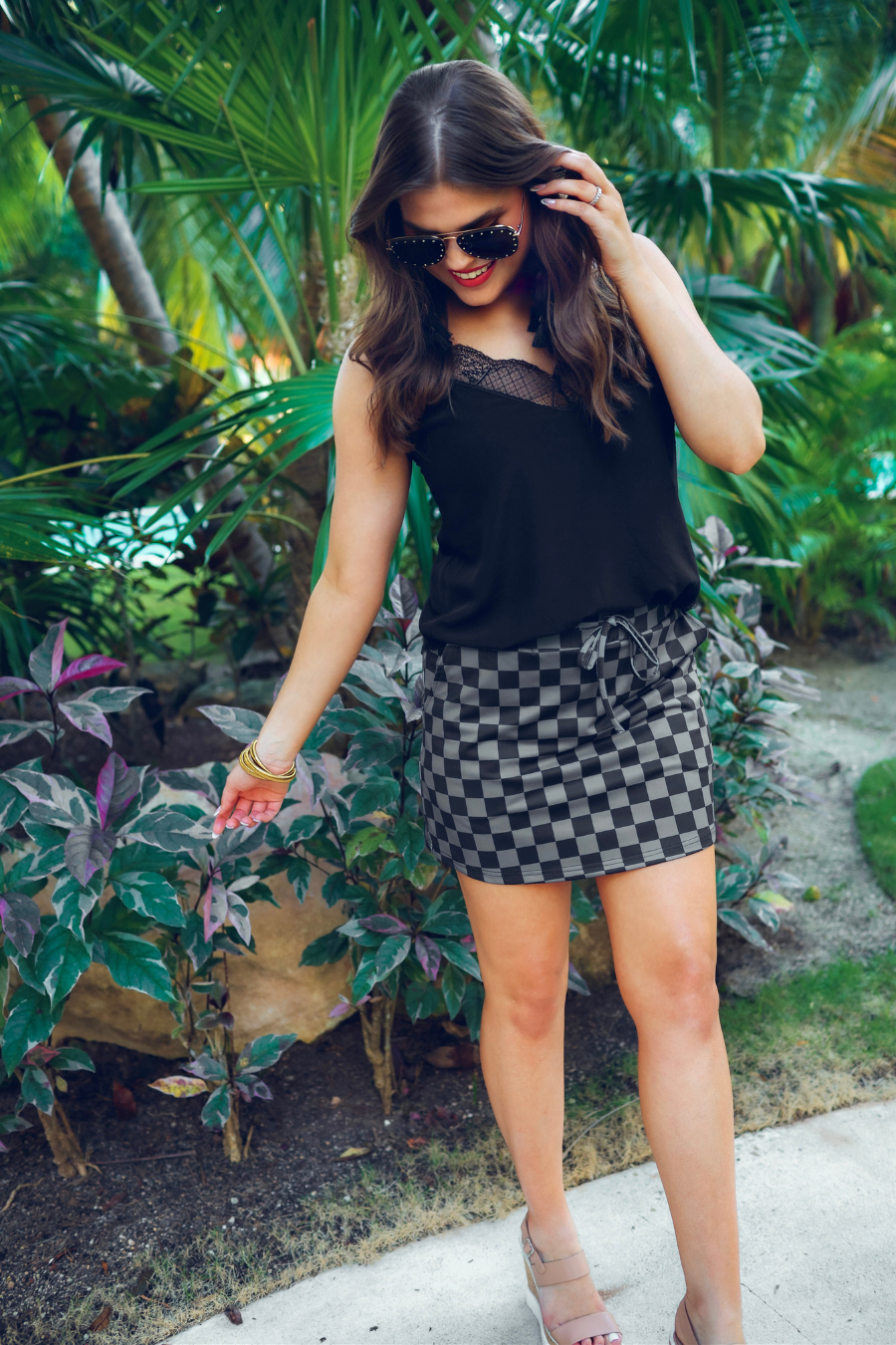 mid-rise relaxed fit everyday skort made of lightweight material with built-in black shorts, drawstring tie, an elastic band on the back, and side pockets, designed on a two-tone black checkered pattern print