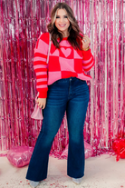 long sleeve sweater made of fuzzy material with a crew neckline on a checkered and stripe pattern fabric