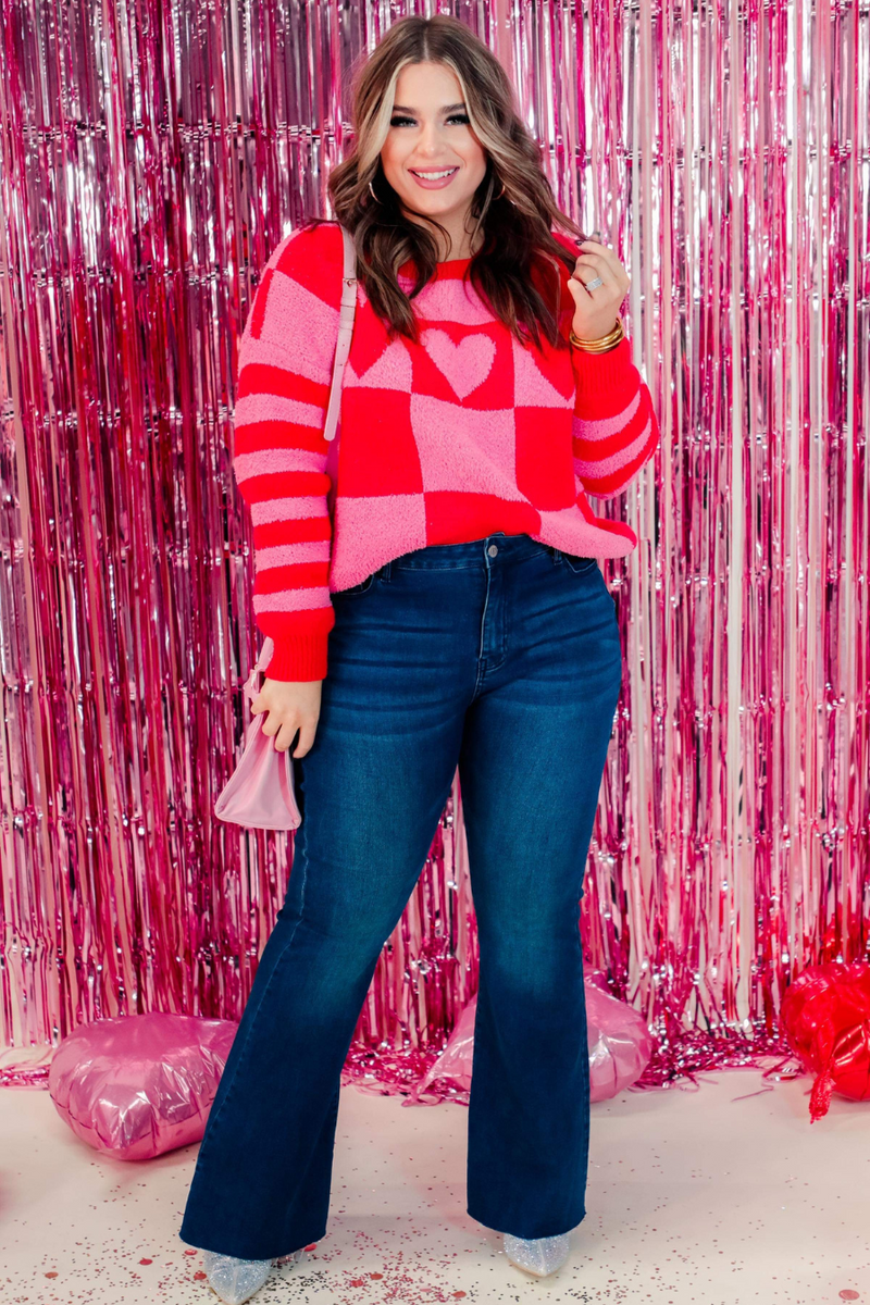 a plush fuzzy knit long-sleeve sweater with a playful mix of checkered blocks, heart motifs, and stripes on contrasting shades, a drop-shoulder fit, and ribbed detailing on the crew neckline, cuffs, and hemline
